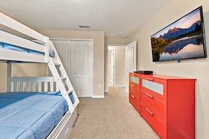 A bedroom with bunk beds, a dresser, and a TV on the wall. - Family 4BR, Private Pool, Resort Amenities (Four Corners)