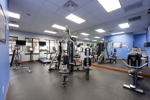 A gym with various exercise equipment, a large mirror, and a blue wall. - Family 4BR, Private Pool, Resort Amenities (Four Corners)