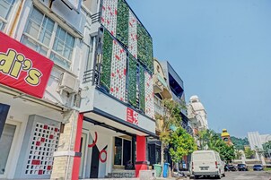A building with a storefront, a sign for 'OYO J&B SMART SENTUL,' and a white van parked in front.