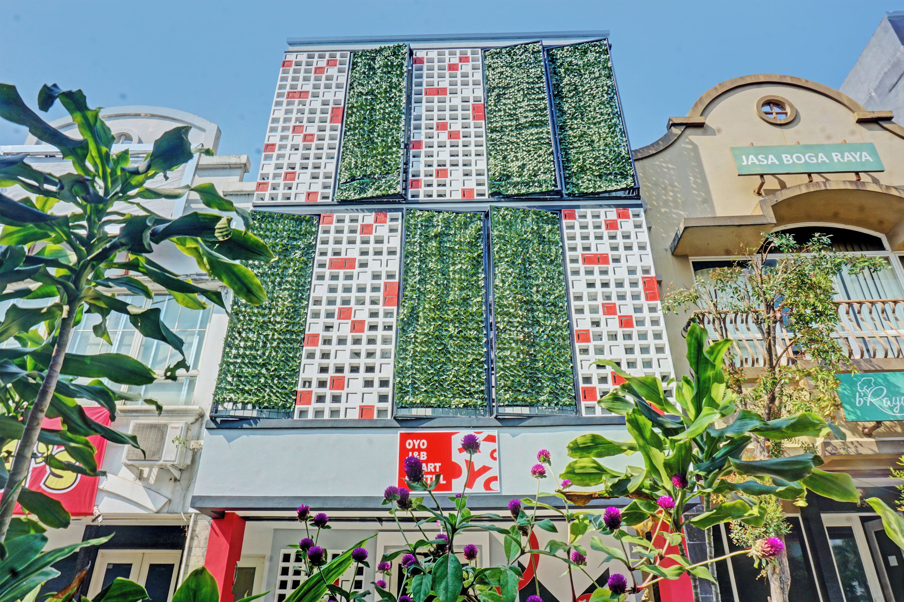 Un edificio con facciata caratterizzata da pannelli giardino verticale e un'insegna con la scritta 'JASA BOGA RAYA'.