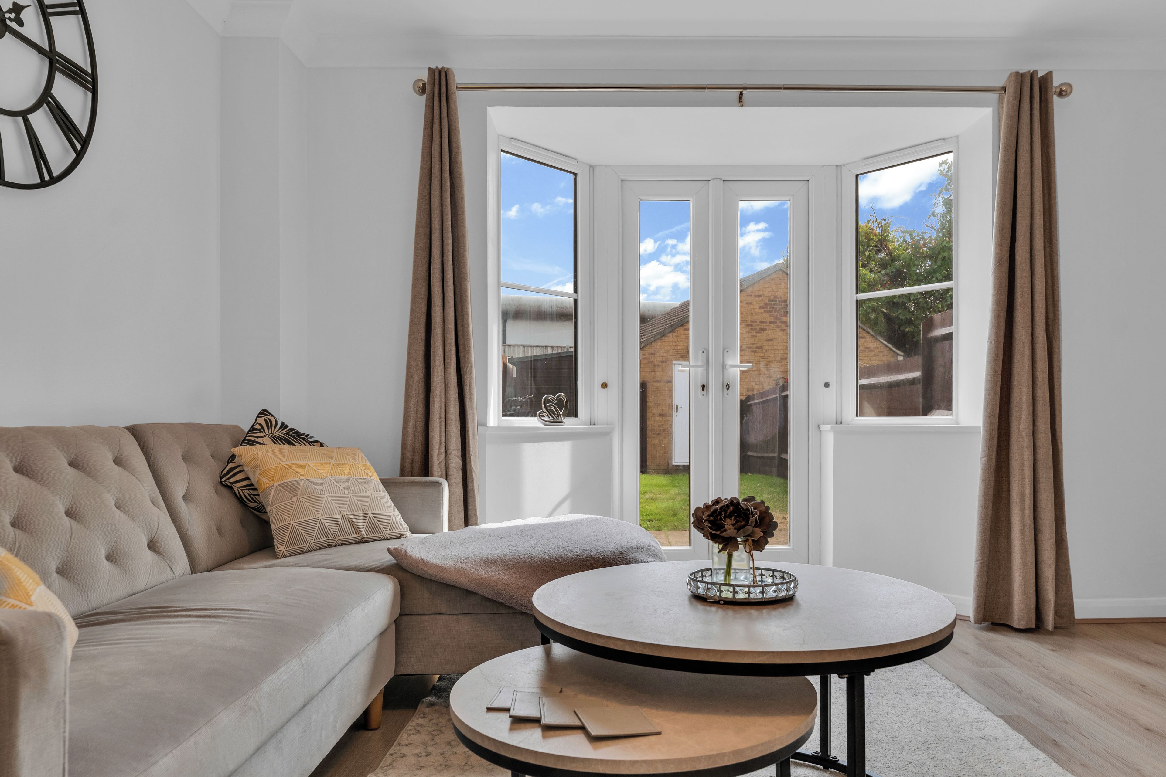 A living room with a sofa, a coffee table, and a view through a glass door to the outside.
