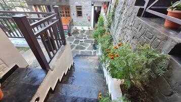 A stone staircase leading to a courtyard with potted plants and a fire extinguisher.