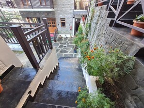 A stone staircase leading to a courtyard with potted plants and a fire extinguisher.