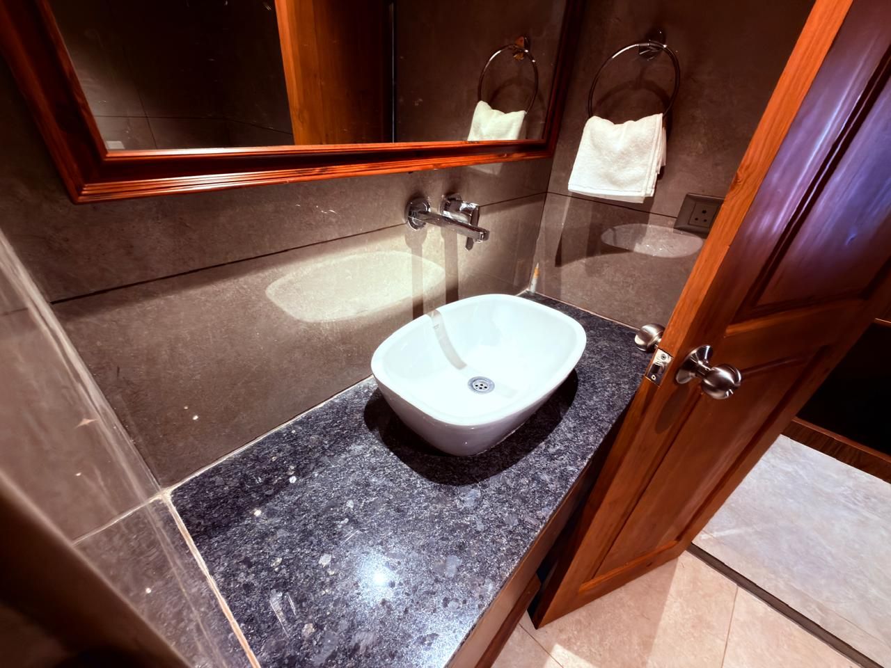 A bathroom with a white sink, a mirror, and a towel rack.