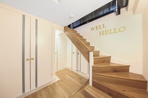Una escalera de madera con un cartel en la pared que dice 'WELL HELLO'.