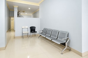 A waiting area with a bench and two chairs, a staircase, and a door marked with the number 206. - Hotel O near UIN Raden Intan (Bandar Lampung)