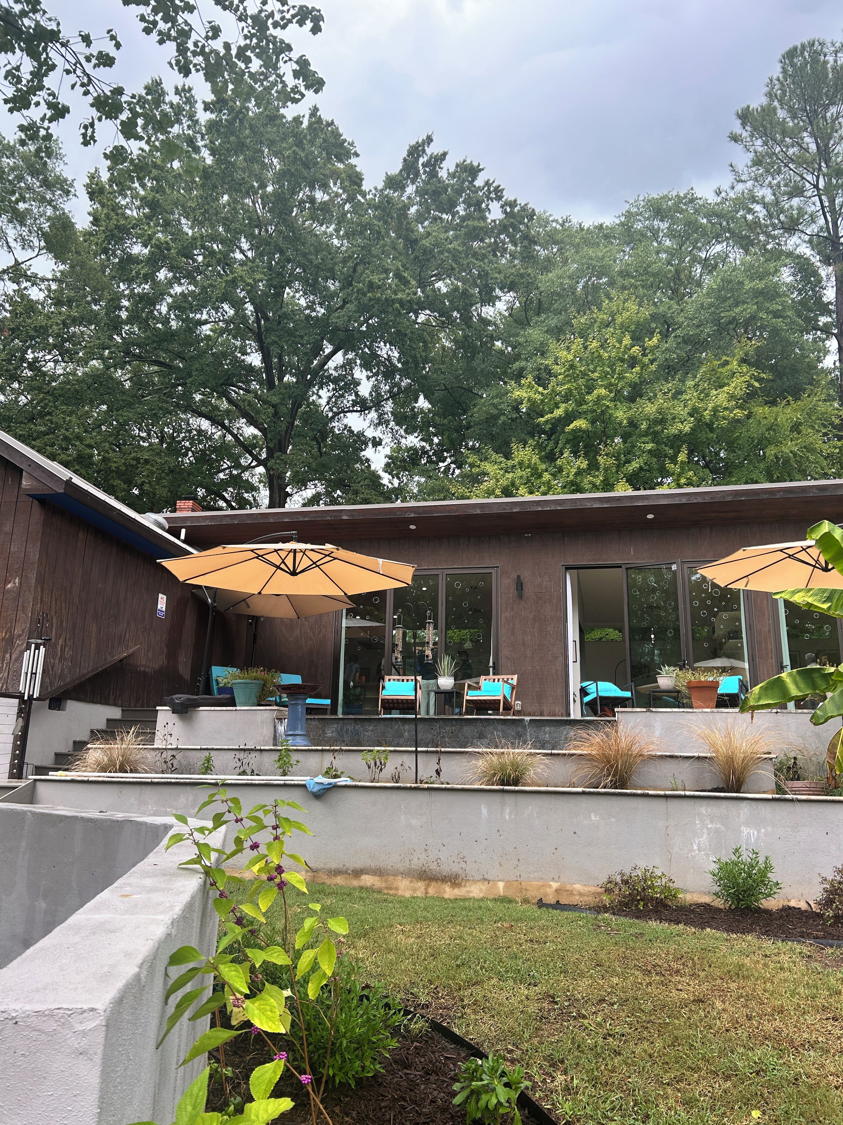 A modern building with a patio area featuring outdoor seating and umbrellas.