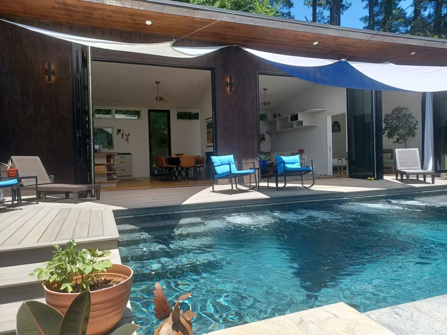 A modern outdoor pool area with lounge chairs and a dining area.