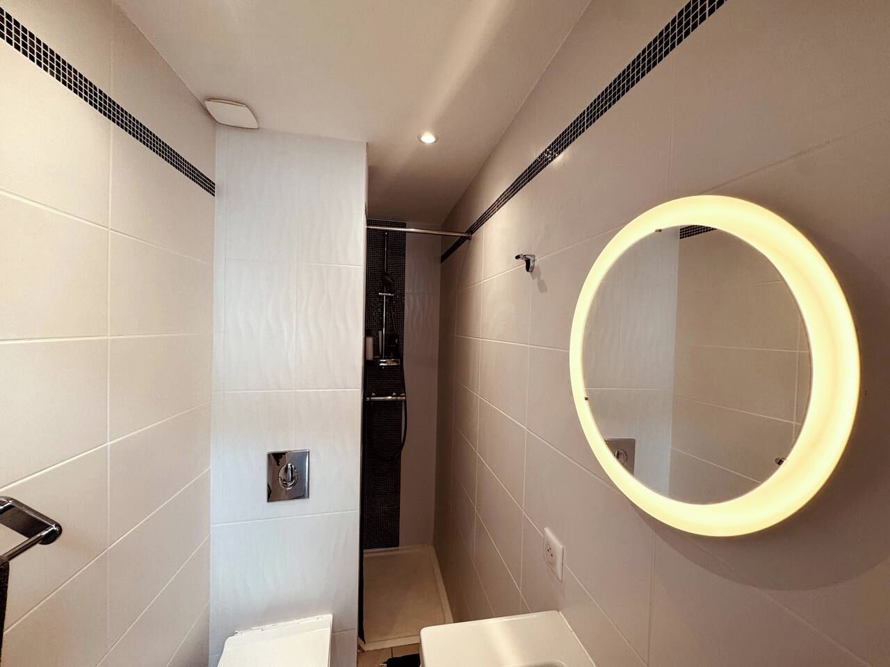 Un baño moderno con inodoro, lavabo y ducha.