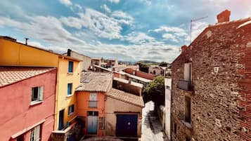 Una calle estrecha flanqueada por edificios, mostrando una mezcla de estilos arquitectónicos y un cielo despejado.