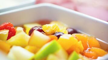 A close-up of a fruit salad in a white bowl.
