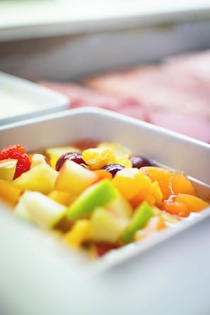 A close-up of a fruit salad in a white bowl.
