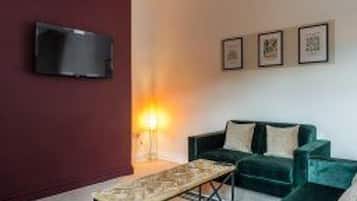 Una sala de estar moderna con un sofá, una mesa de centro y un televisor de pantalla plana montado en la pared.