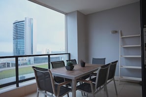 A balcony with a dining table and chairs, a potted plant, and a metal ladder. - 2-bedroom apartment in charming Durban with AC for relaxing stays (Durban)
