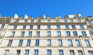A multi-story building with a classical architectural style, featuring a row of windows on each floor, balconies, and a flat roof with chimneys. - AN EXCEPTIONAL CENTRAL LOCATION FOR AN UNFORGETTABLE PARISIAN STAY-RUE DE RIVOLI (Paris)