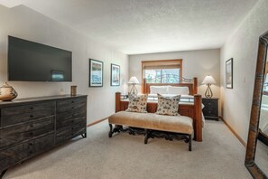 A bedroom with a bed, bedside tables, a dresser, a mirror, and a television. - Ski-In/Ski-Out Snowbird Sanctuary 687 (Mammoth Lakes)