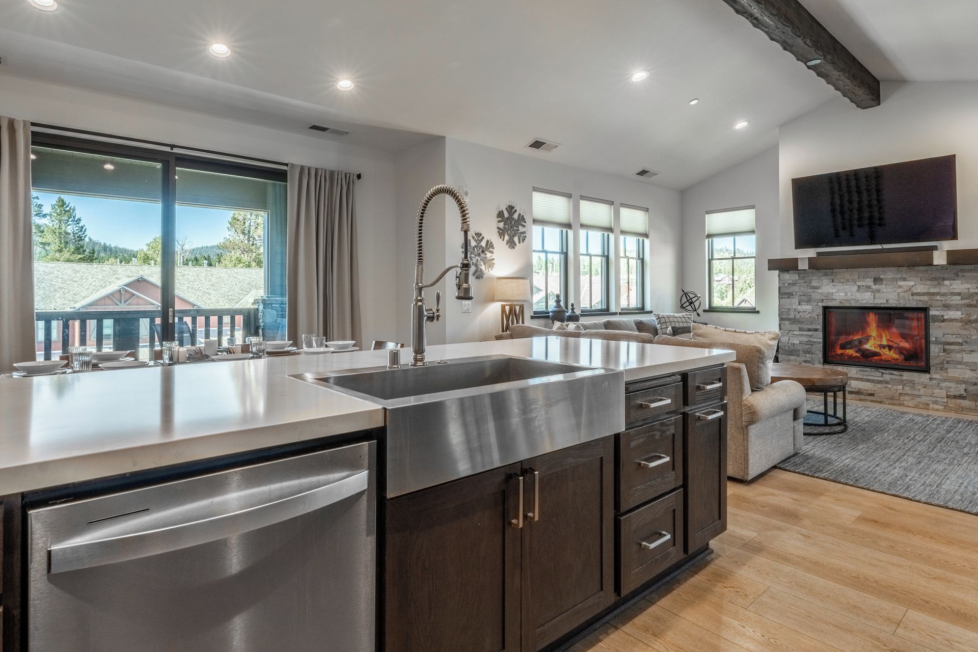 A modern kitchen with a large island, built-in appliances, and a fireplace.
