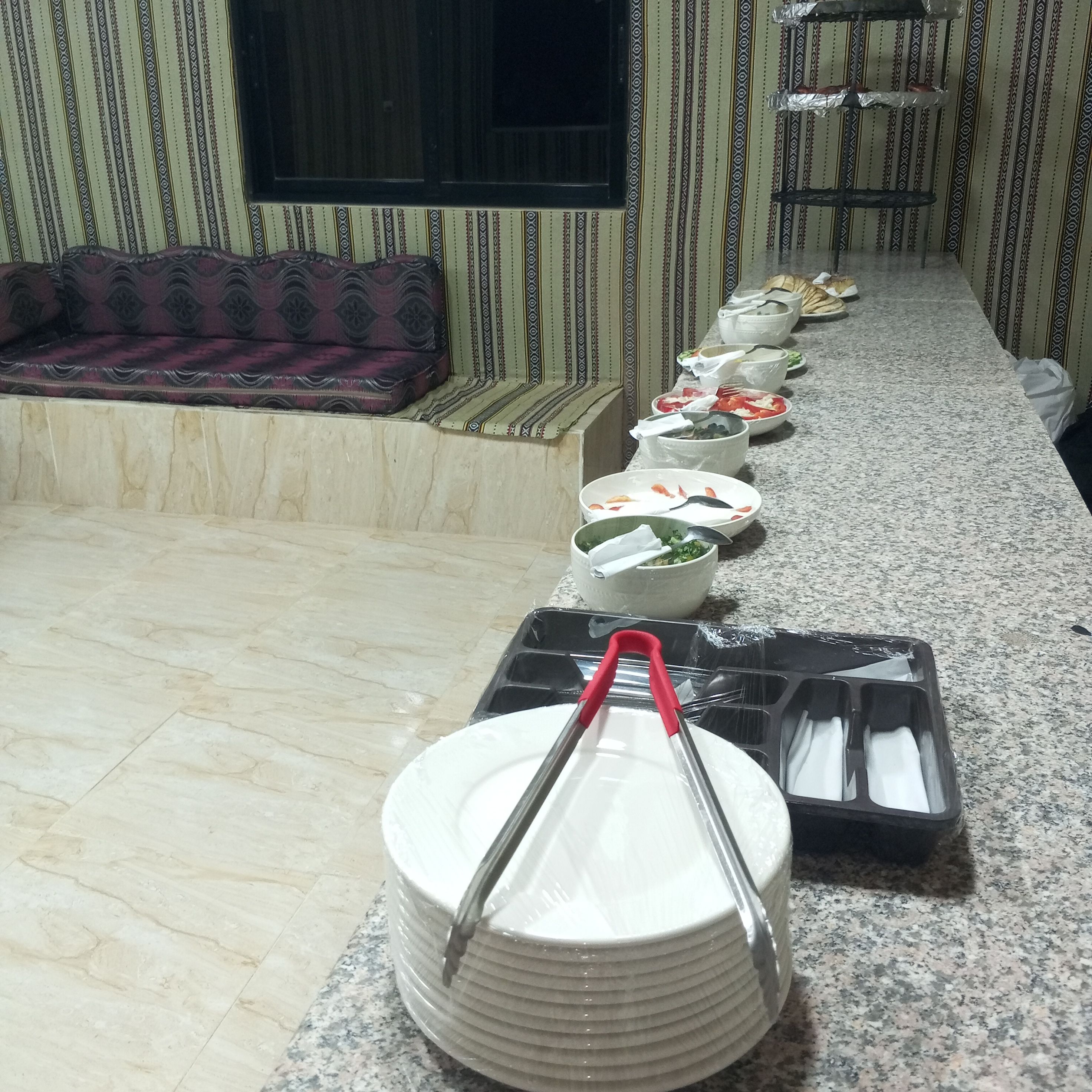 Ein reichhaltiges Buffet mit verschiedenen Schalen und Tellern auf einer Granitabdeckung.