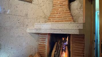 Une cheminée en briques, un tableau encadré accroché au mur et un cadre de porte en bois.