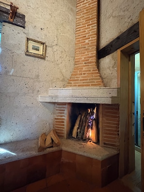A fireplace with a brick chimney, a framed picture on the wall, and a wooden door frame.