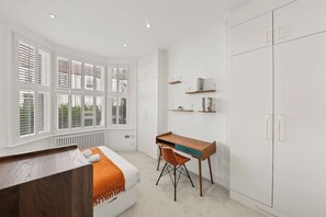 Une chambre à coucher avec un lit, un bureau et une armoire.
