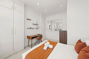 A modern hotel room with a bed, a desk, and a wardrobe. - Bright 2 bed Chiswick by ARP Homes l 5 min tube & Heathrow (Greater London)