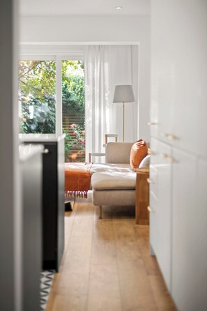 A modern kitchen with a dining area, a sofa with a cushion, and a lamp. - Bright 2 bed Chiswick by ARP Homes l 5 min tube & Heathrow (Greater London)