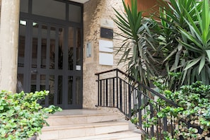 A building entrance with a metal gate, a staircase, and a stone wall. - ElleEsse Apartment: Between Ortigia and the Archaeological Park. Two bathrooms, large living room (Siracusa)