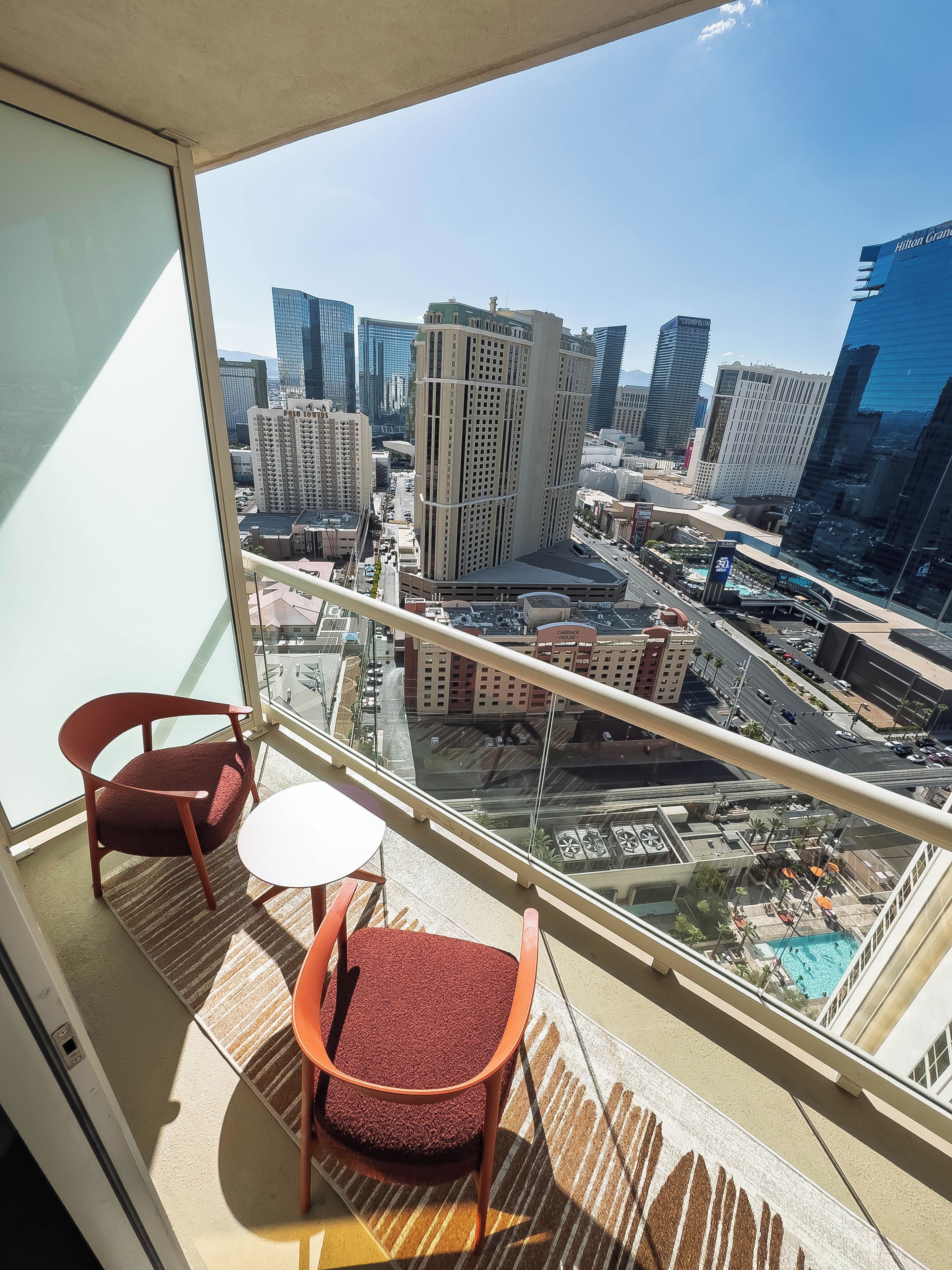 Un balcon offrant une vue sur le paysage urbain, avec notamment des immeubles de grande hauteur et un casino.