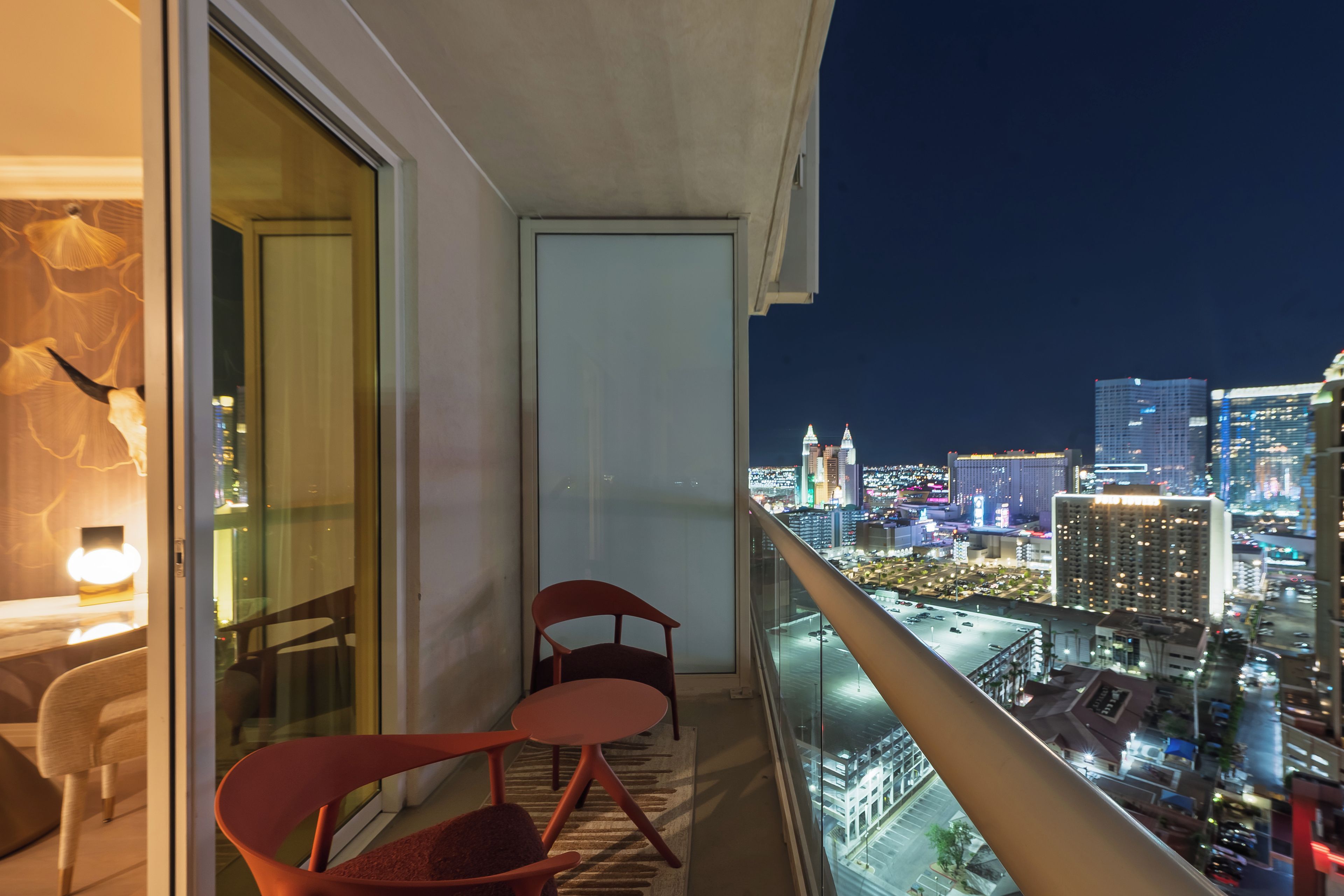 A balcony with a city view at night.