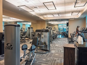 A gym with exercise equipment, treadmills, and a mirrored wall. - Remodeled High Floor Strip View Balcony (Las Vegas)