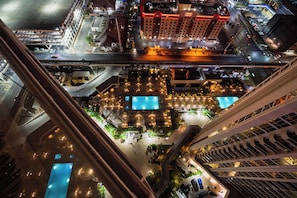 A high-rise hotel with multiple swimming pools, a rooftop bar, and a view of the cityscape. - Remodeled High Floor Strip View Balcony (Las Vegas)