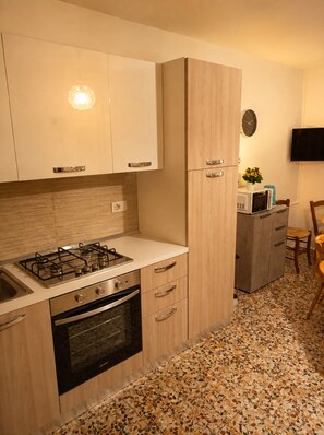 Eine moderne Küche mit Gasherd, Backofen und Holzschränken.