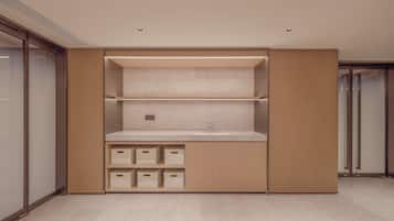 A modern bathroom with a built-in sink, storage cabinets, and a shower area.