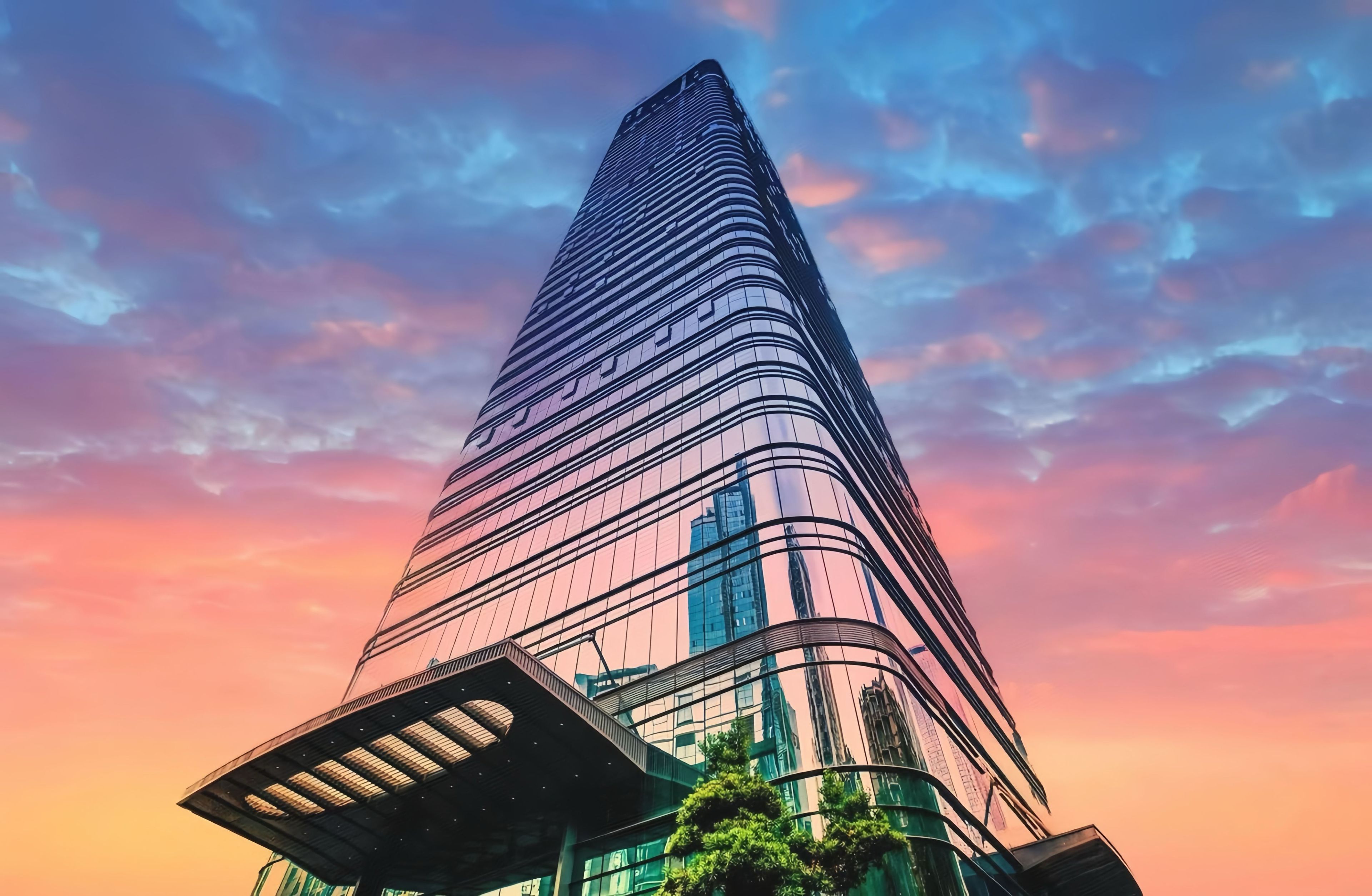 A tall, modern skyscraper with a curved facade and a distinctive architectural design.