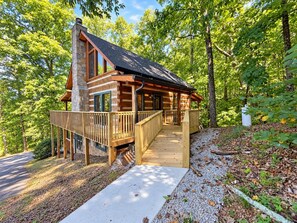 A cabin with a wooden deck, a stone chimney, and a gravel driveway. - Catnapping Cabin Hot Tub 7 minutes to main strip (Sevierville)