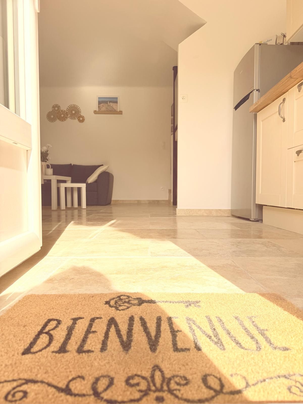 A hallway with a welcome mat leading to a dining area.