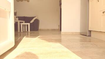 A hallway with a welcome mat leading to a dining area.