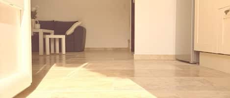 A hallway with a welcome mat leading to a dining area.