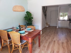 A dining area with a wooden table, blue plates, and wicker chairs. - A bungalow perfect for families. Air conditioning in every room. Access to the pool. (L'Alfàs del Pi)