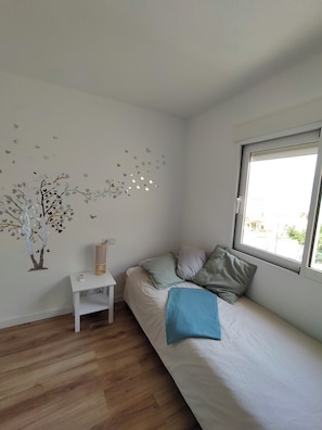 A bedroom with a bed, a bedside table, a wall-mounted shelf, and a window. - A bungalow perfect for families. Air conditioning in every room. Access to the pool. (L'Alfàs del Pi)