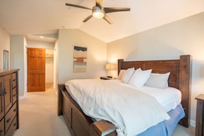 A bedroom with a bed, wooden headboard, a ceiling fan, a nightstand, and a dresser. - Park City Creekside Luxury Townhome: Private Hot Tub, Ski Shuttle, Corner Unit (Park City)