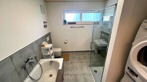 Ein kleines Badezimmer mit Badewanne, Toilette und einer Duschkabine.