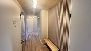 A hallway with a wooden bench, a mirror, and a door. - Berg Apartment with a Balcony and a View of Nature in Herrischried – My SWH (Herrischried)