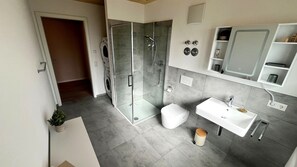 A modern bathroom with a glass shower enclosure, a white sink, and a toilet. - Apartment by the Lake with a Balcony and a View of Nature in Herrischried – Mein SWH (Herrischried)