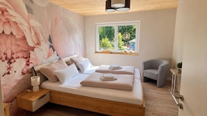 A bedroom with a bed, bedside table, and a chair. - Apartment by the Lake with a Balcony and a View of Nature in Herrischried – Mein SWH (Herrischried)