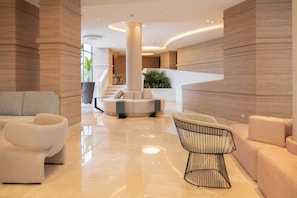 A modern lobby with a central column, a staircase, and seating areas. - Morros Park. Exclusive Beach & Nature Retreat (Bolívar)