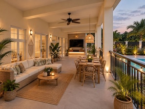 A spacious living area with a sofa, dining table, and chairs, a ceiling fan, and a view of a pool. - Luxurious 6 bed, 7 bath estate in Fitches Creek for large families and groups (Fitches Creek)