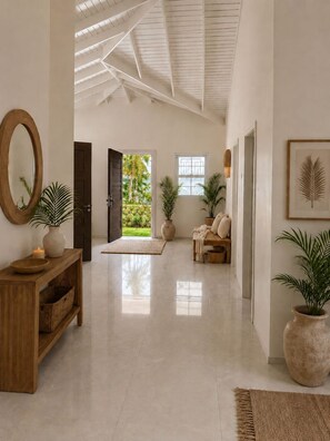 A spacious hallway with a high ceiling, a wooden console table, a mirror, and a door leading to a garden. - Luxurious 6 bed, 7 bath estate in Fitches Creek for large families and groups (Fitches Creek)