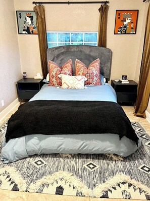 A bedroom with a bed, two nightstands, a window, and two wall art pieces. - Stylish 3-Bedroom, 2 Bath Home near Tampa Airport, Downtown & Raymond James Stadium (Tampa)